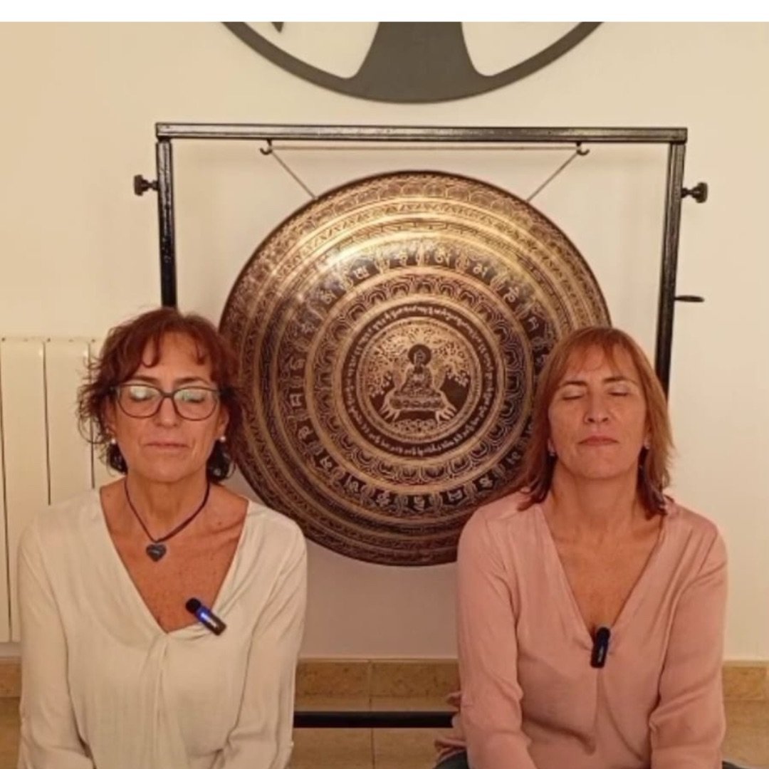 Maribel y Sonia sentadas en meditación frente al gong.