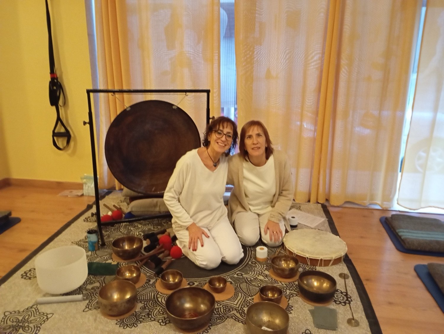 Maribel y Sonia, vestidas de blanco, junto al gong y el set completo de cuencos.