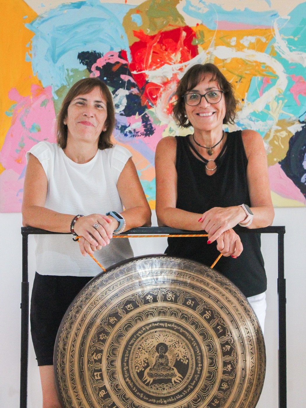 Maribel y Sonia, sonriendo junto al gong en su espacio de terapias.